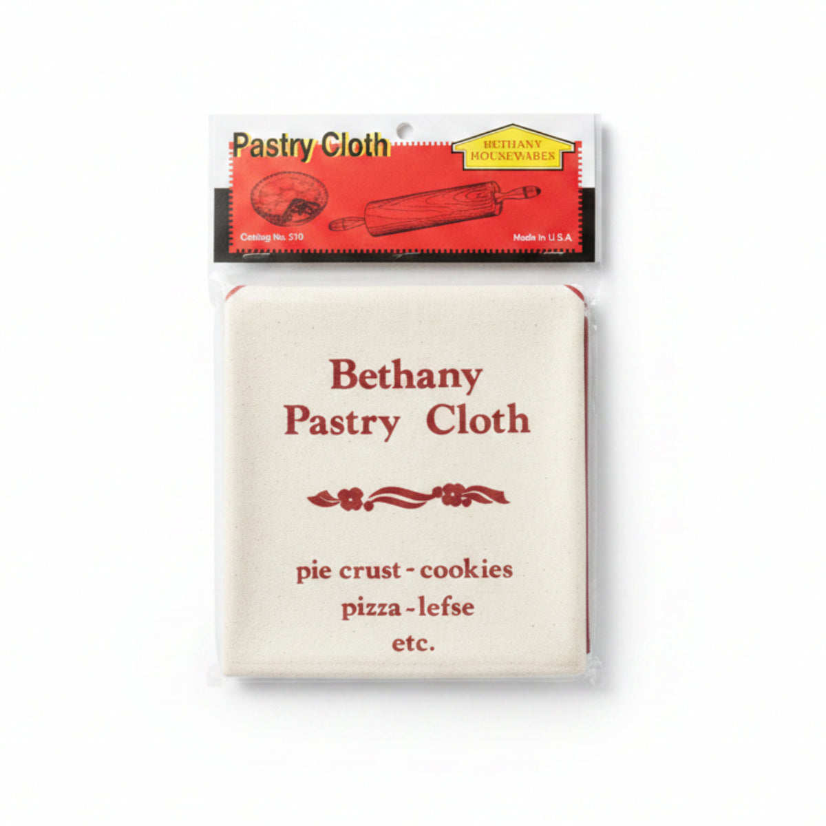 A packaged Bethany Housewares pastry cloth in clear plastic wrapping with a red and white header card, placed on a gray textured surface. The cloth itself is off-white with red printed text listing food types it resists, including pie crust, cookies, pizza, and lefse.