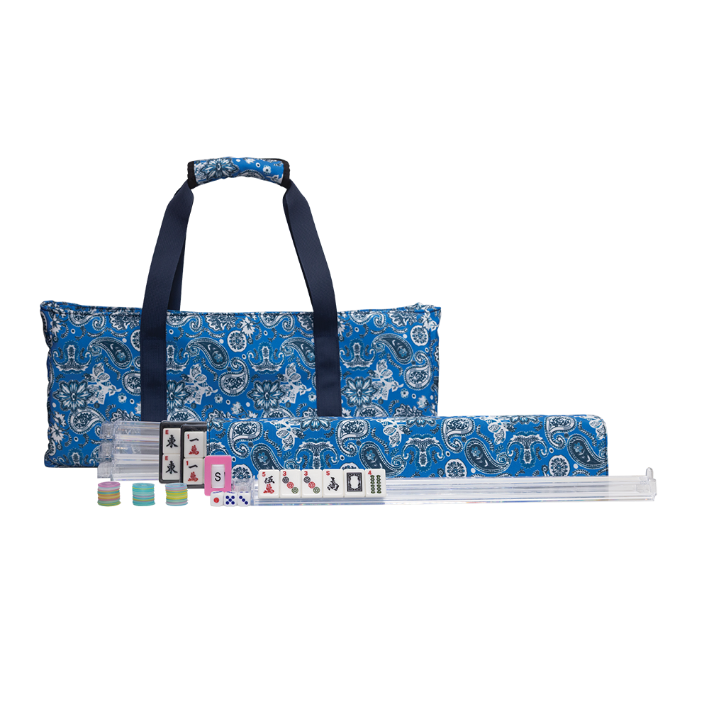 A Mahjong set displayed on a clean white background, featuring a blue patterned carrying bag with dark navy handles, a matching rolled case, and several tiles laid out in front.