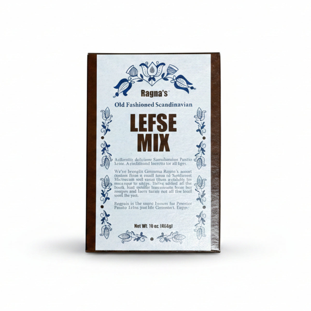 A rectangular box of Ragna's Lefse Mix placed on a textured gray concrete surface. The box has a white front label with blue decorative floral borders and brown text, with a dark brown side edge.